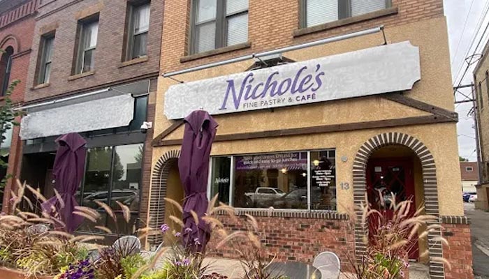 Nichole's Fine Pastry & Café exterior with outdoor seating, purple umbrellas, and event space.